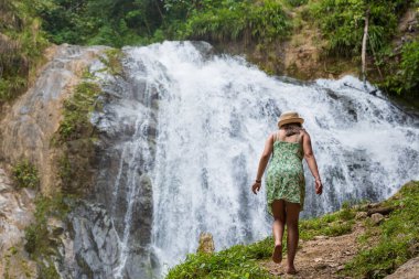 Turist kadın Peru ormanlarında bir şelaleye doğru yürüyor..
