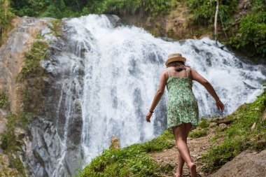 Turist kadın Peru ormanlarında bir şelaleye doğru yürüyor..