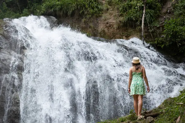 Kadın gezgin Peru ormanlarında bir şelale düşünüyor..