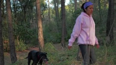 Sabahları yaşlı köpeğiyle ağaçların ve çimenlerin arasında dolaşan bir kadın..
