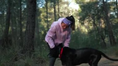 Bir kadın sabah onunla yürürken ormanda köpeğiyle oynuyor..