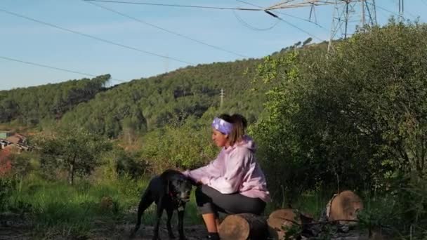 Una Mujer Acaricia Perro Mientras Descansa Sobre Algunos Troncos Bosque — Vídeo de stock