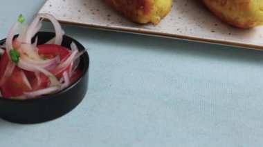 Geleneksel Peru yemeği: soğan ve domates salatasıyla servis edilen lezzetli dolma patatesler.