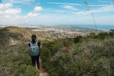 Yürüyüşçü şehre doğru iniyor, nefes kesici manzarası var..