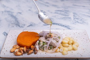 Ceviche adlı geleneksel Peru yemeğinin suyunu kaşık dolduruyor..