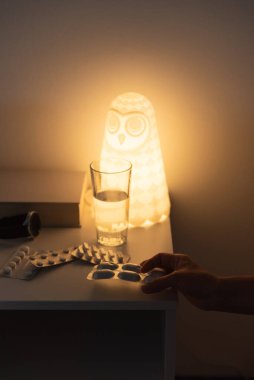 Bir insanın eli geceleri ilaçlarını tutuyor..