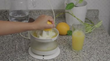 Bir insan evinin mutfağında doğal bir portakal suyu hazırlar..