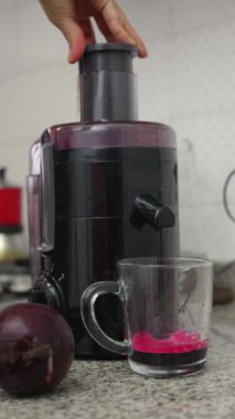 Ev mutfağındaki meyve sıkacağında taze hazırlanmış pancar suyu..