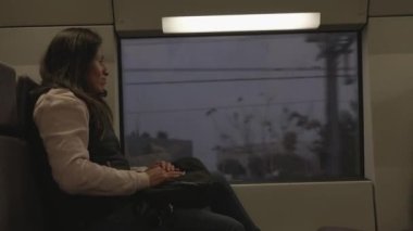 Yorgun görünen kadın işten sonra trenle eve dönüyor..