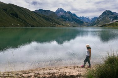 Peru 'daki Querococha gölünün kıyısında bir kadın yürüyor..