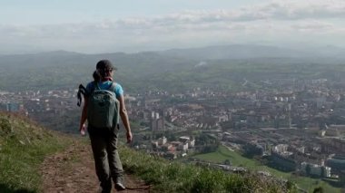 Bir kadın yürüyüşçü İspanya 'nın güzel şehri Oviedo' ya bakarken Naranco Dağı 'na tırmanır..