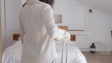 Bir kadın tatilden kalma bir bavulla evine gelir ve rahatça yatağa düşer..