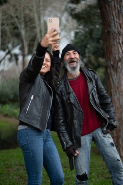 Yaşlı bir adam genç bir kadınla selfie çekerken eğleniyor..