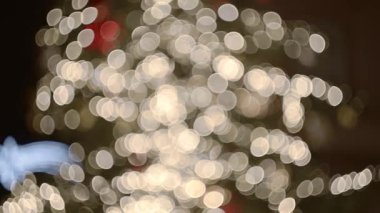 Odaklanamayan ışıklarla çevrili bir Noel ağacının güzel görüntüsü.
