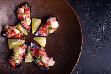 Peru mutfağı yukarıdan görünüyor ve siyah bir arkaplanda servis ediliyor, adı Choros a la chalaca..