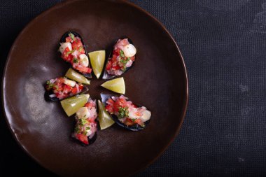 Karanlık bir arka planda Choros a la Chalaca tabağı, Peru 'da çok popüler bir aperatif..