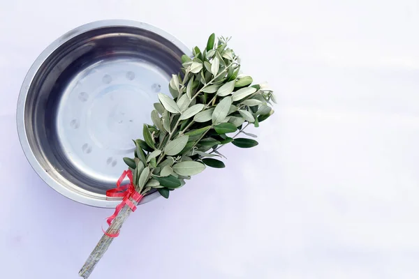 Holy Week. bundle of branches and basin with holy water to sprinkle. Traditional Catholic celebration Palm Sunday. Christian faith. Religious symbol.