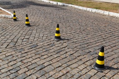 Trafik işareti koni sarı ve siyah renkler, sert plastik, taştan halka açık yolda
