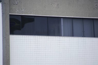reflection of the Brazilian flag in a dark window of a building