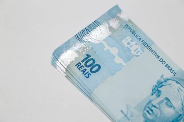 several hundred real bills - money from Brazil on neutral white background