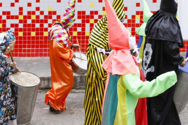 Minas Gerais, Brazil - March 4, 2019: masqueraders known as cainaguas wearing their characteristic colorful clothes on the streets during carnival in the interior of Minas Gerais