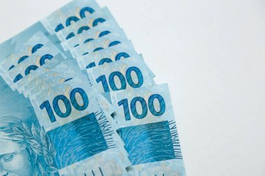 several hundred real bills - money from Brazil on neutral white background