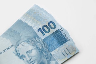 several hundred real bills - money from Brazil on neutral white background