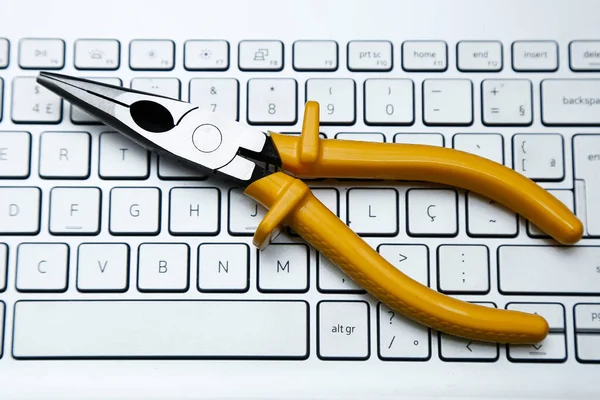 Metal pense aracı ve sarı yalıtım ve hafif tonlu bilgisayar klavyesi