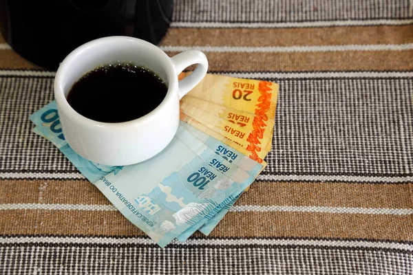 cup of coffee and banknotes of real money from brazil