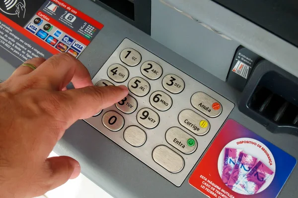 Minas Gerais, Brazil - February 24, 2023: detail on the use of an ATM at Bradesco bank
