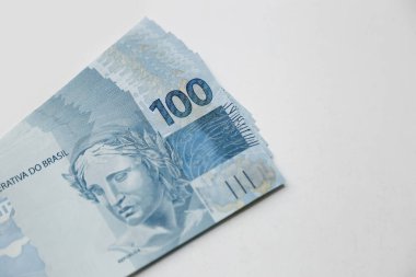 several hundred real bills - money from Brazil on neutral white background