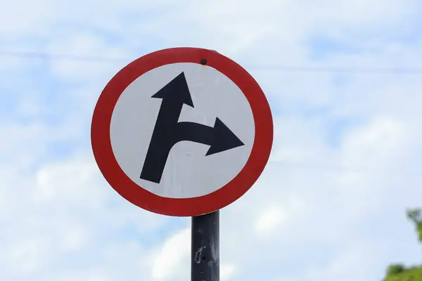 white traffic sign indicating direction ahead and right - go in two directions