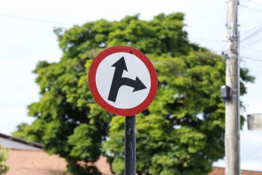 İleride ve sağda işaret eden beyaz trafik işareti - iki yönde gidin