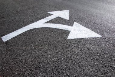 Asfalt zemine beyaz yönlü ok çizildi - yollar ve yönler kavramı