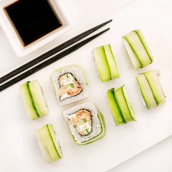 Sushi Plat Pada Latar Belakang Putih Gulungan Diatur Dengan Mentimun — Stok Foto