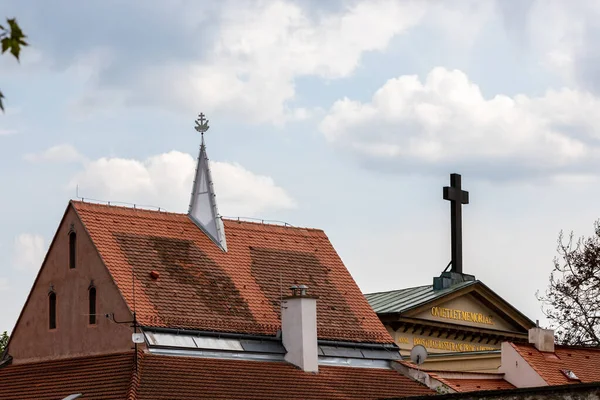 Metal dekoratif haç, gökyüzü arka planında kahverengi metal çatı. Gökyüzünü koruyan dini haç. Litvanya 'nın Kaunas kentindeki bulutlu gökyüzü arka planında çatı ve çapraz geçiş. 