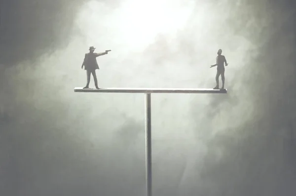 stock image concept of two men fighting on unstable structure, karma concept