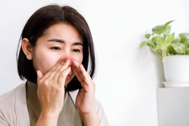 Asyalı kadın sinüs sorunları nedeniyle burun tıkanıklığı yaşıyor