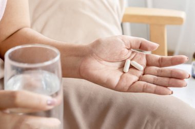 Kadın eli, enfeksiyonla savaşmak ve ishalden kurtulmak için probiyotik alıyor.