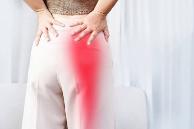 Sciatica Pain concept with woman suffering from buttock pain spreading to down leg clipart