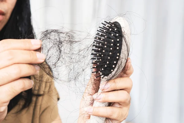 stock image hair loss women, closeup hair fall on comb after brushing caused by allergic to shampoo, medicine or depression