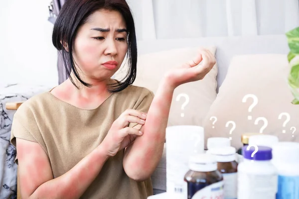 Asian women scratching on itchy, rash skin caused by allergic reactions to supplements and side effects from too much taking multivitamins