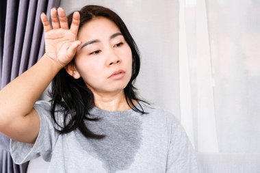 sweating Asian woman in summer with hot weather wearing sweat shirt clipart