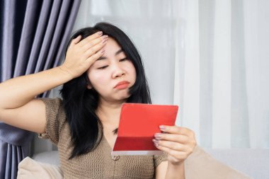 Tasarruf defterine bakan Asyalı kadın para sayısından endişeleniyor. 