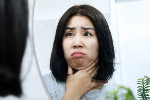 鏡の前で彼女の下顎の下に彼女の二重顎をチェックするアジアの女性を心配 体重増加や肥満の兆候 — ストック写真