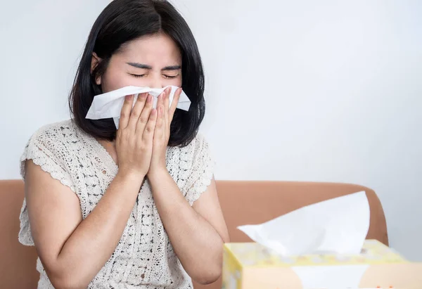 Asian woman sneezing because of cold and flu, dust allergy