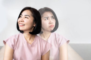 bipolar disorder concept with double personality Asian woman in difference emotional face angry and happy   clipart