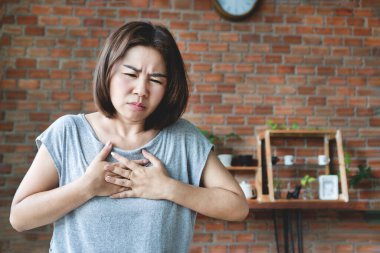 Kalp krizi geçiren Asyalı kadın, göğüs ağrısı ve nefes almakta zorlanıyor. 