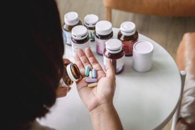 Yakın plan kadın ilave hapları elinde tutarken mütivitamin alıyor. 