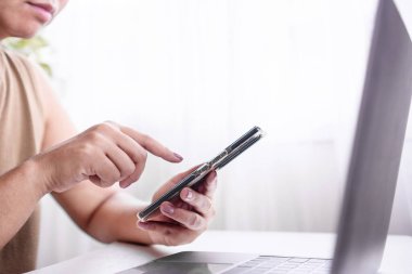 Yakın plan kadın el araması akıllı telefon, dizüstü bilgisayar, internet konseptine bağlanan teknolojiye sahip insanlar 